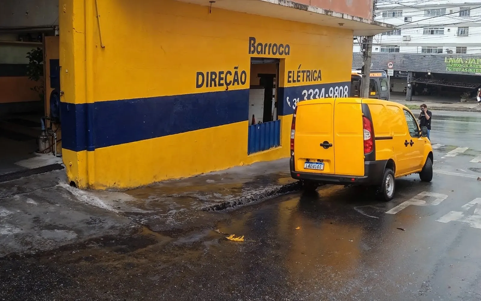 Fachada da Barroca Direções Hidráulicas: parede amarela e azul com o nome, DIREÇÃO ELÉTRICA e o telefone (31) 3334-9808 pintados